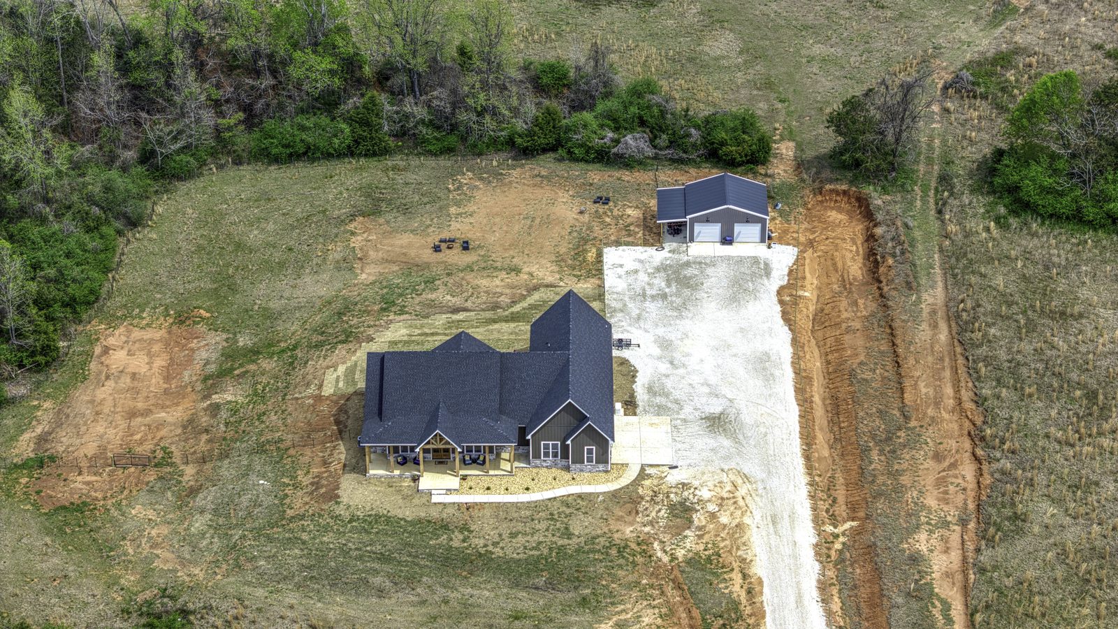 The Stone Craftsman aerial view of the home, drive and shop