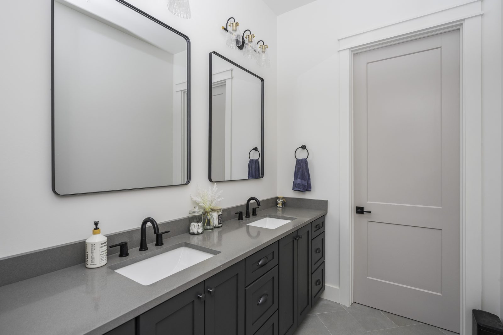 The Stone Craftsman bathroom with double vanity and black mirrors