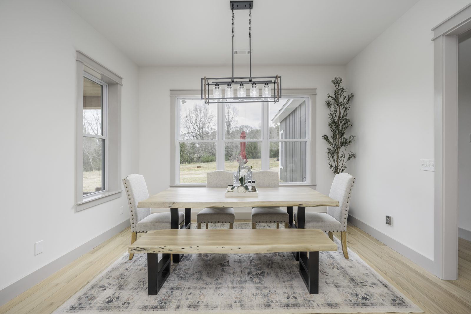 The Stone Craftsman dining area with iron chandelier and large window