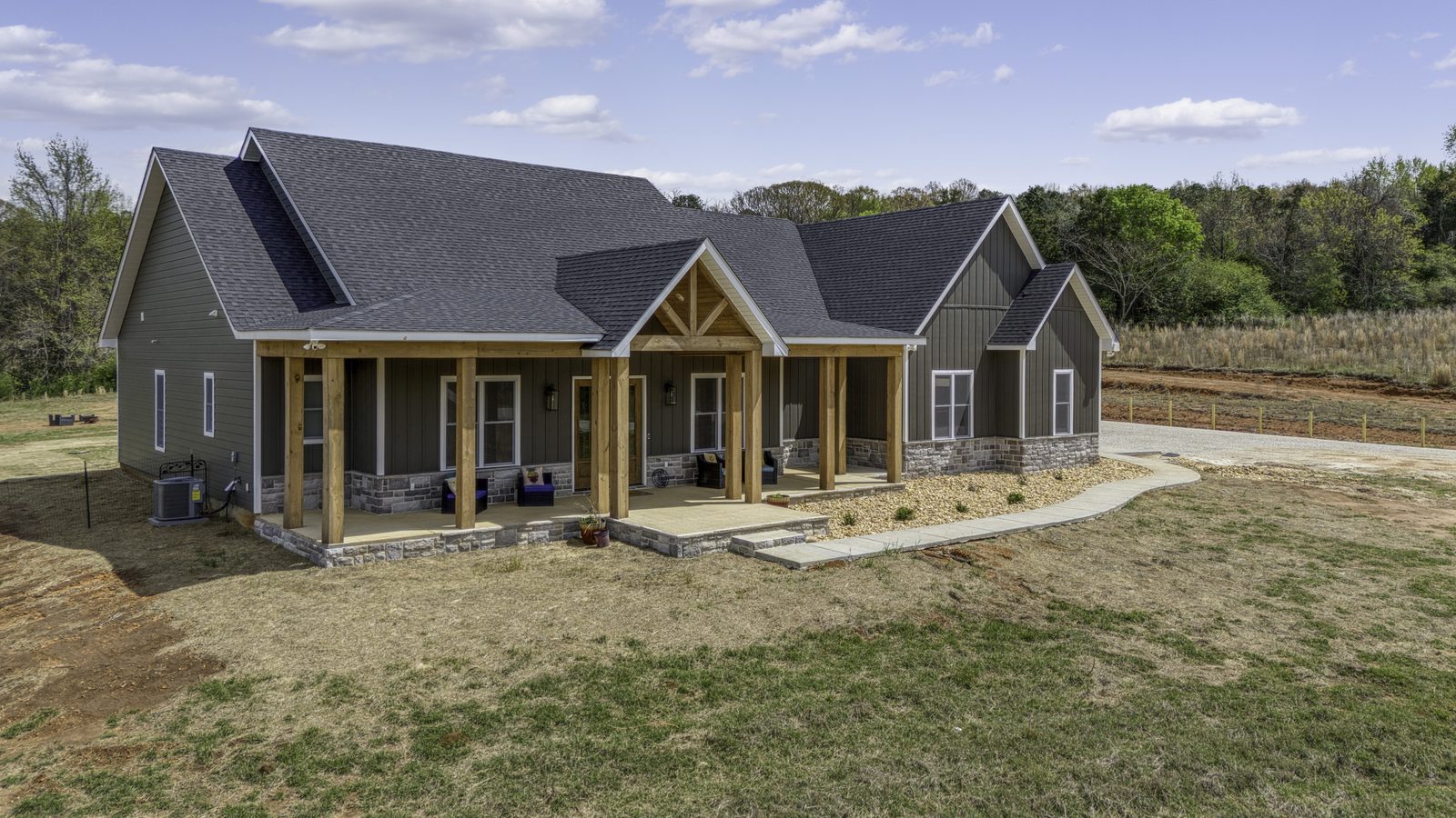 The Stone Craftsman exterior with gabled craftsman porch, cedar posts and stone skirting