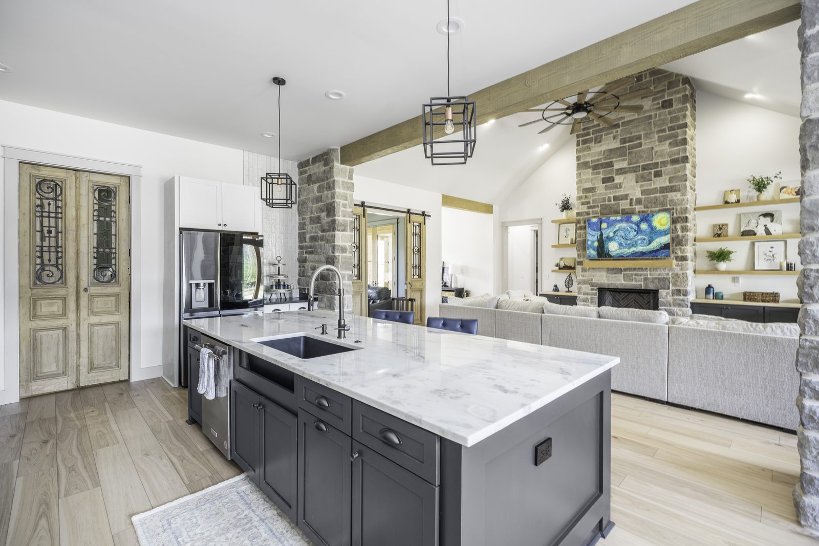 The Stone Craftsman quartz island looking into the living room with stone fireplace