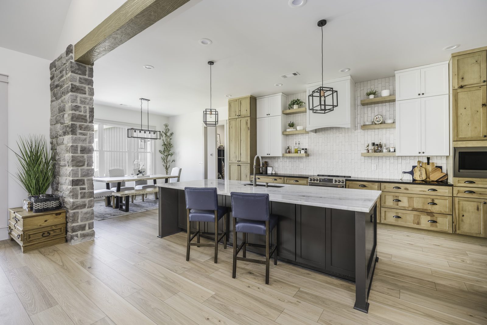 The Stone Craftsman kitchen with stone column and wood beam opening to the dining area