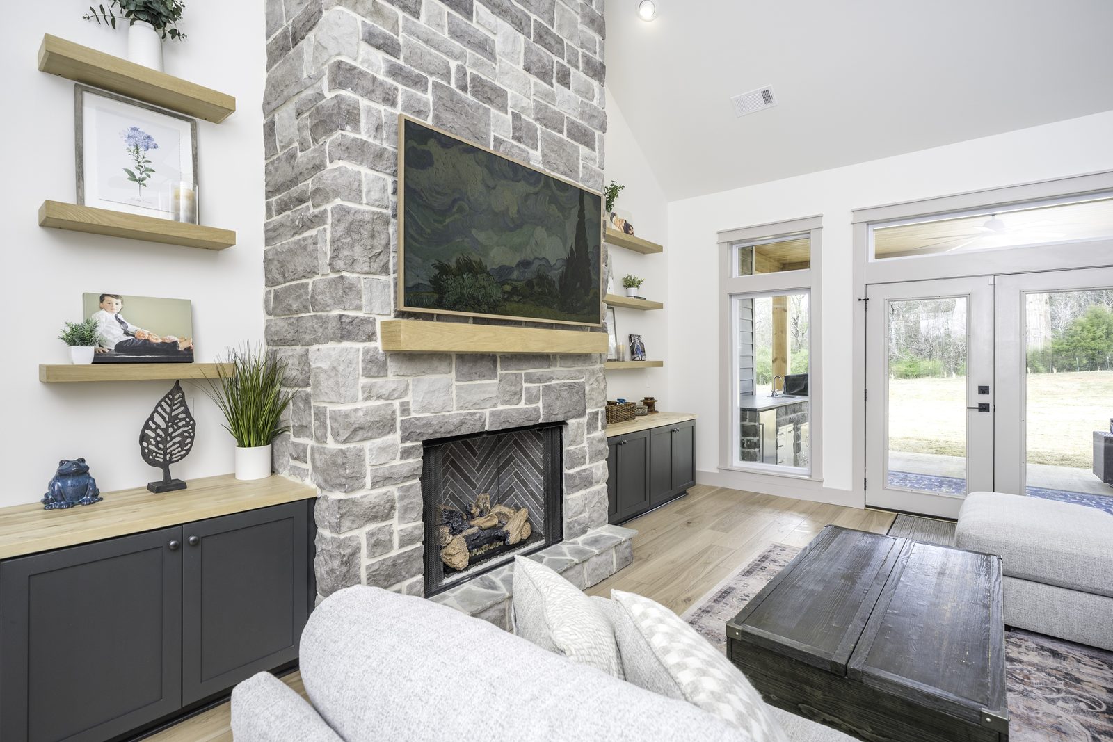 The Stone Craftsman stone fireplace with built-in cabinets and shelves