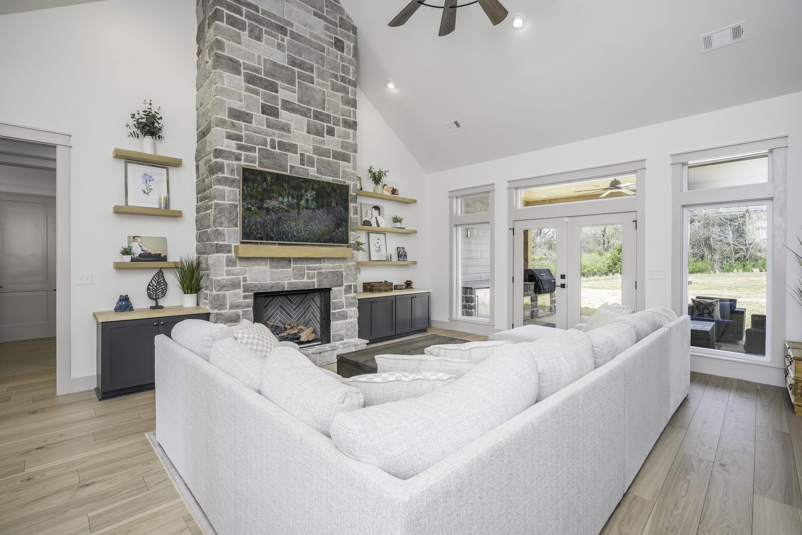 The Stone Craftsman vaulted living room with sectional and stone fireplace