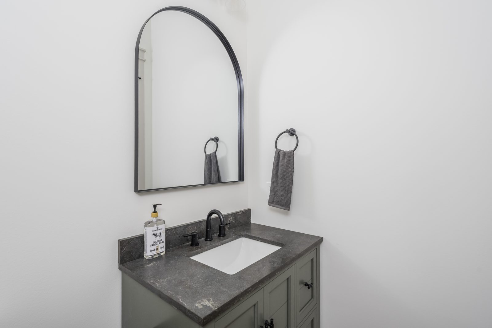 The Stone Craftsman powder room vanity with arched mirror