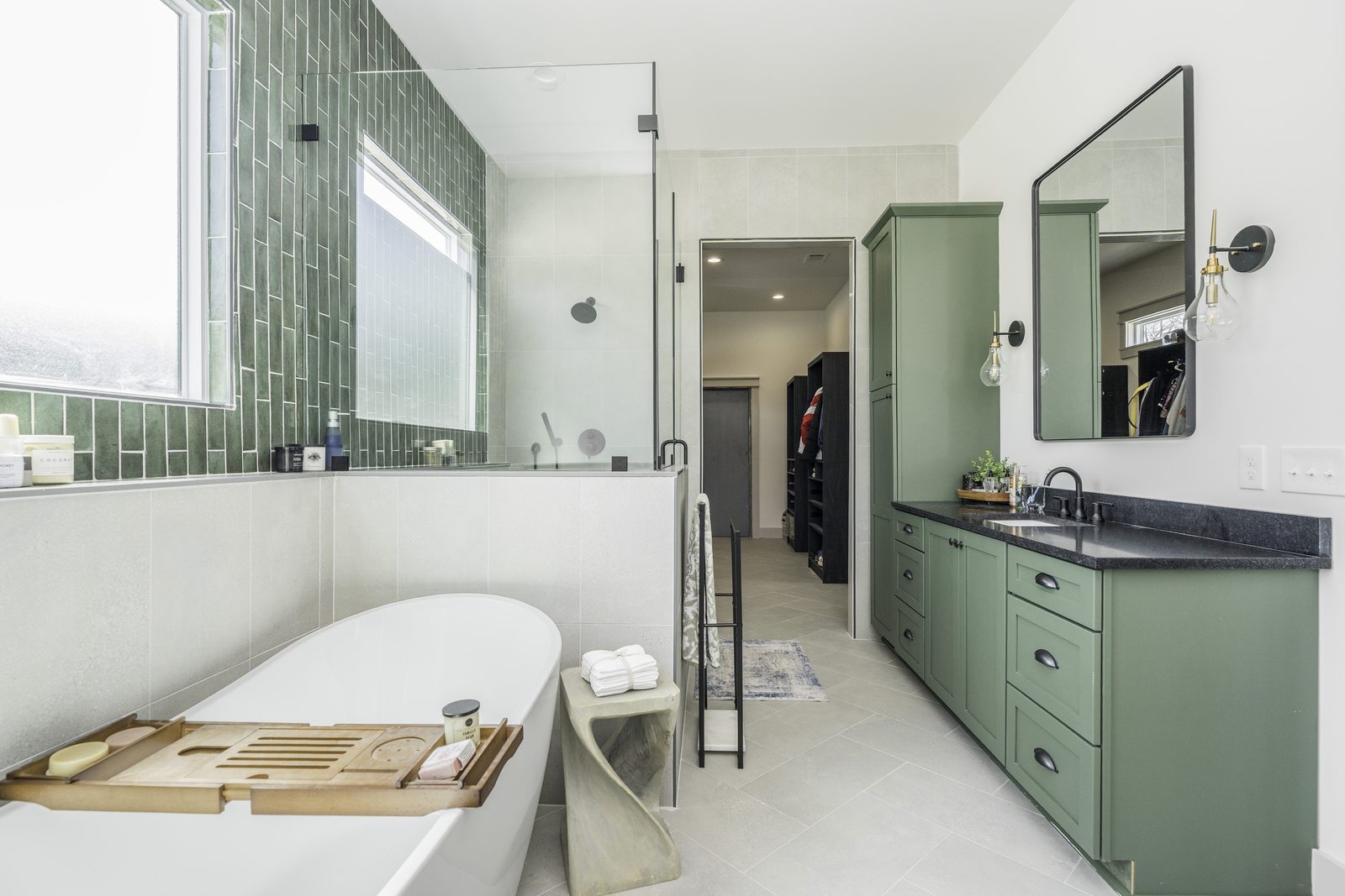 The Stone Craftsman primary bath with freestanding tub and green vanity