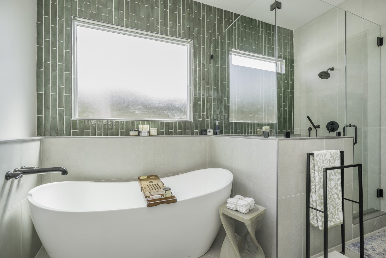 The Stone Craftsman primary bath with freestanding tub, green tile and glass shower