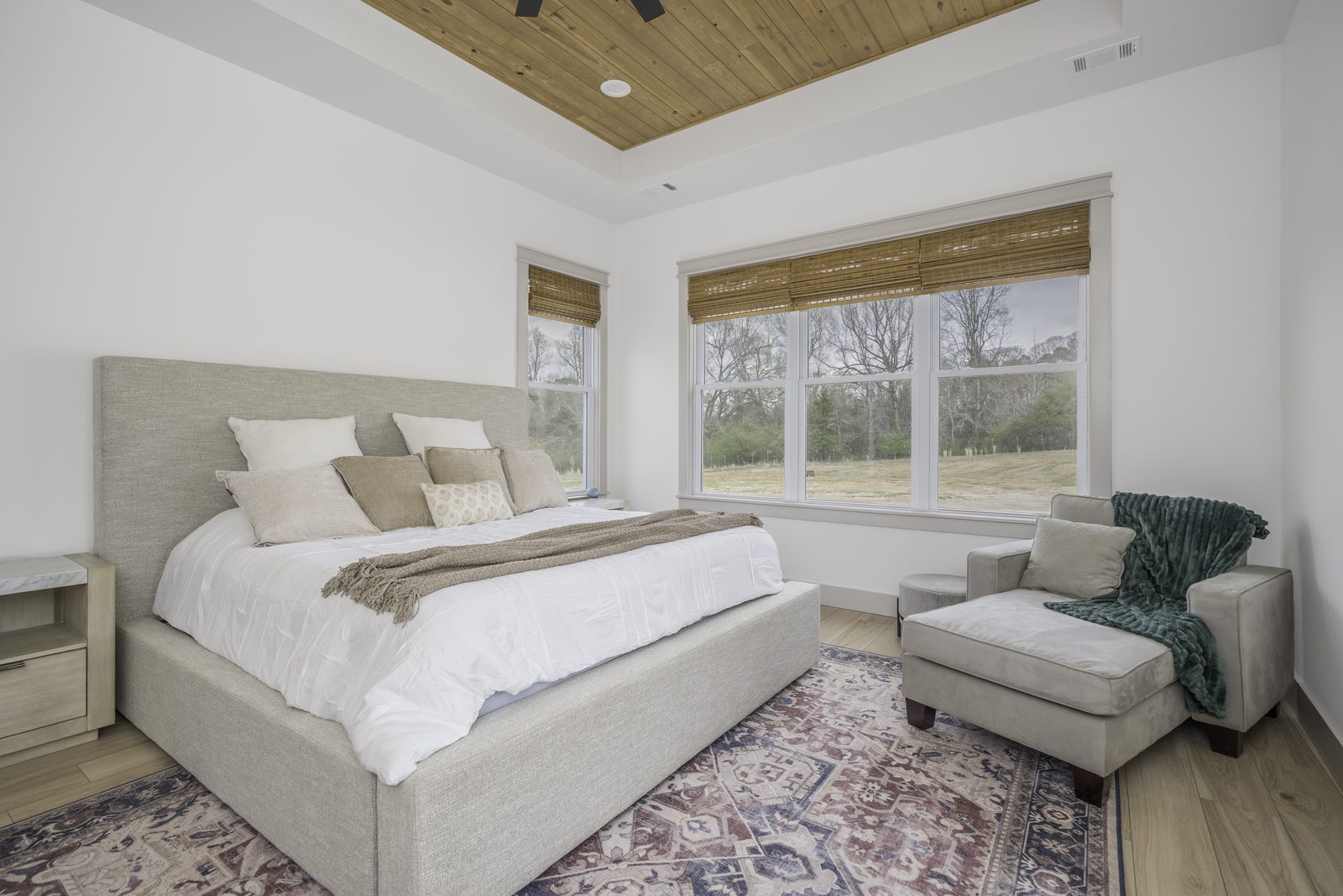 The Stone Craftsman primary bedroom with wood plank tray ceiling