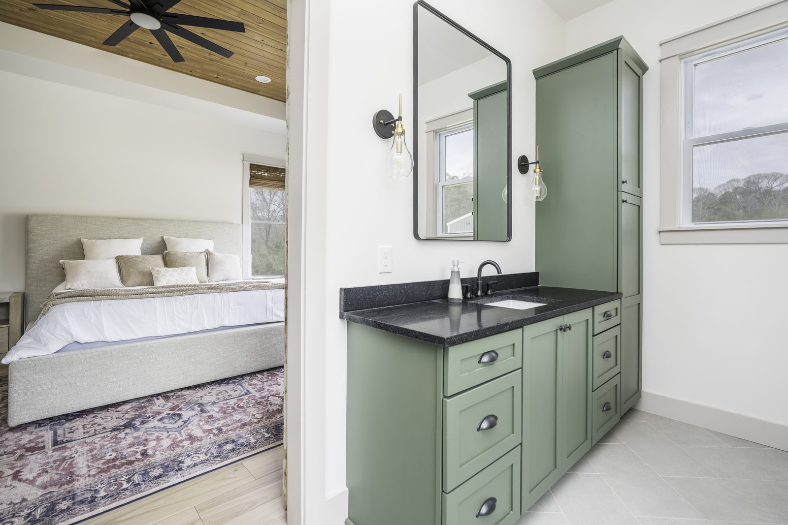 The Stone Craftsman primary bath green vanity with black mirror