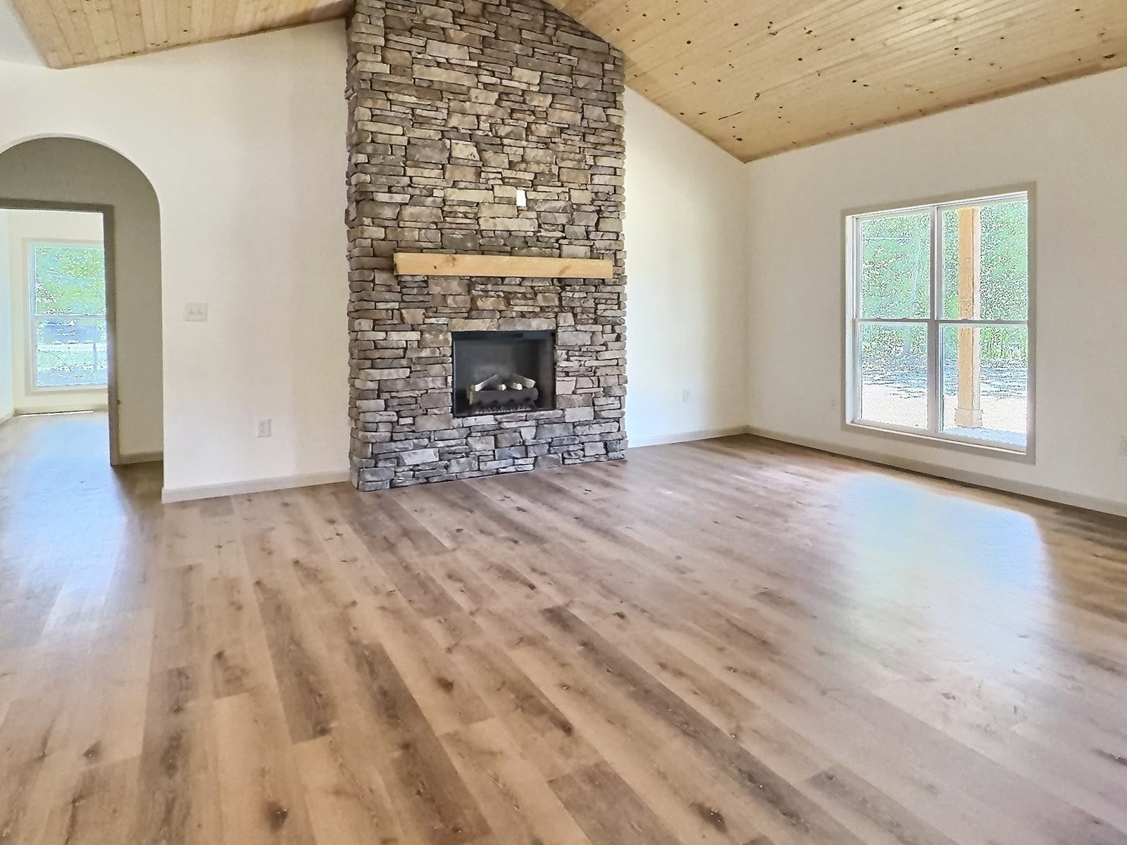 The Cedar Ranch stacked stone fireplace under a wood plank vaulted ceiling