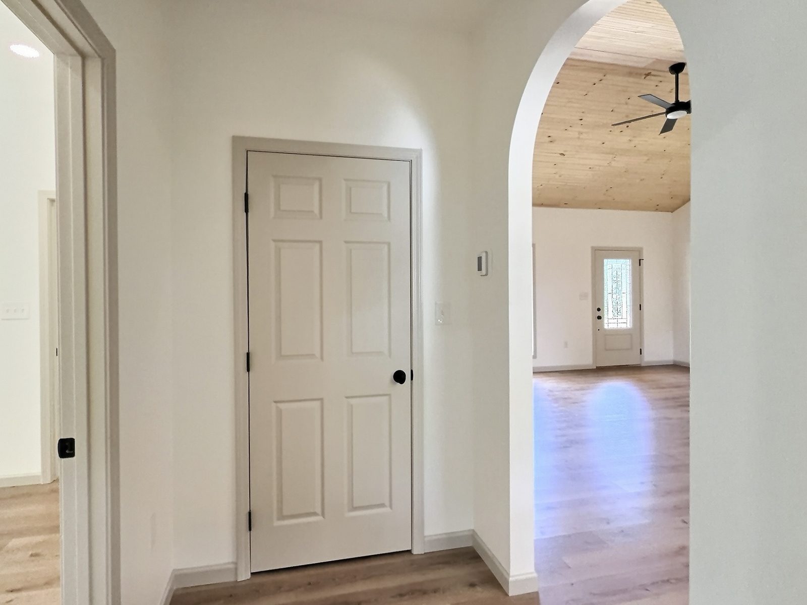 The Cedar Ranch hallway with arched opening to the living room