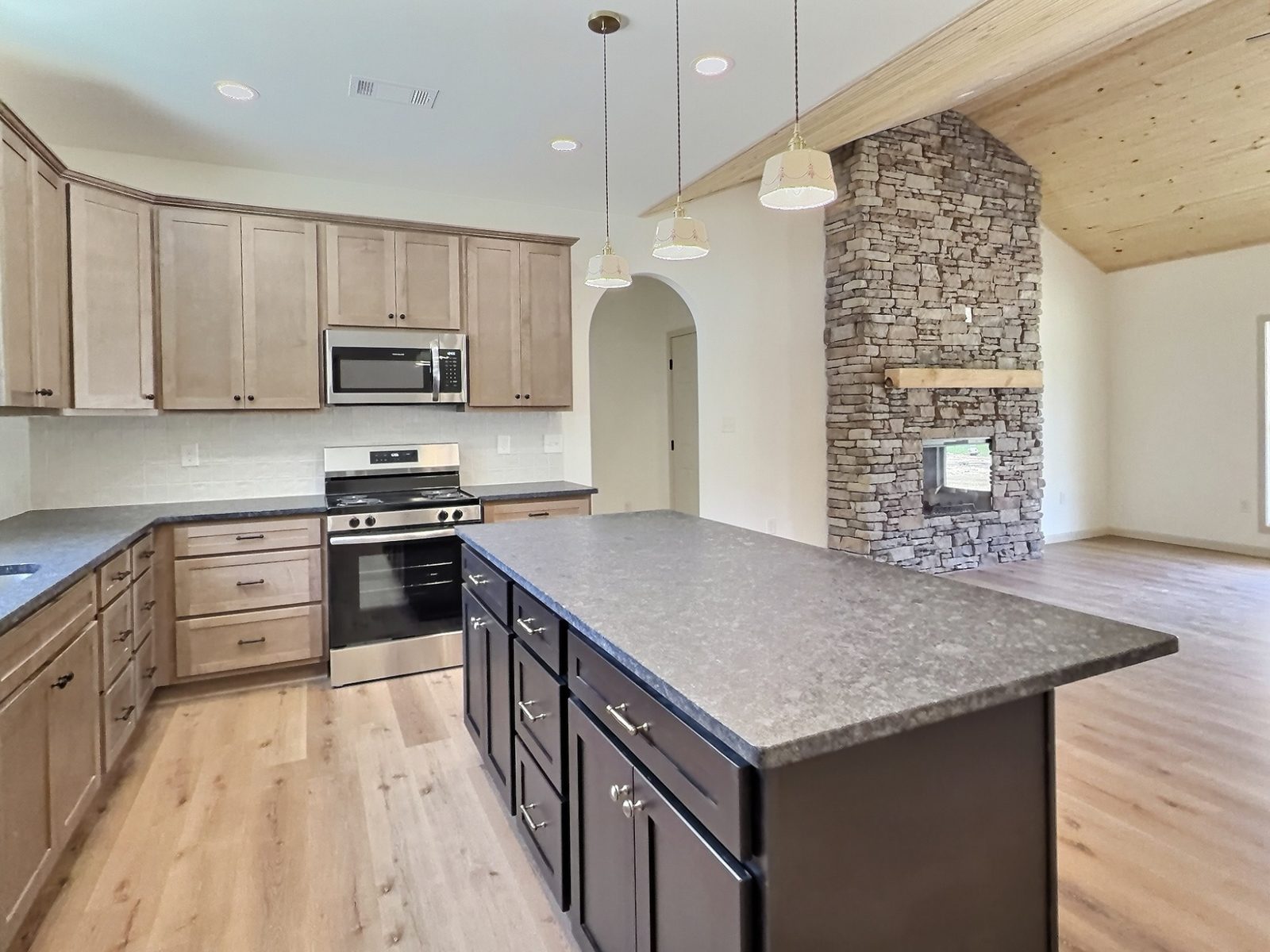 The Cedar Ranch kitchen island looking toward the stacked stone fireplace