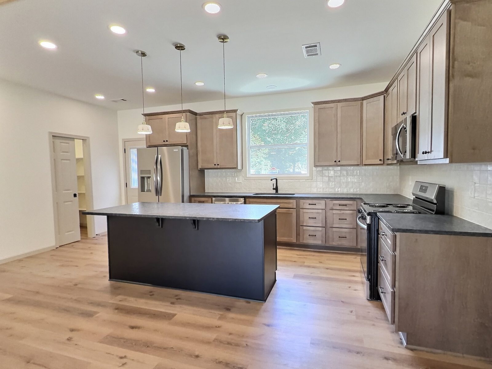 The Cedar Ranch kitchen with dark island and stainless appliances