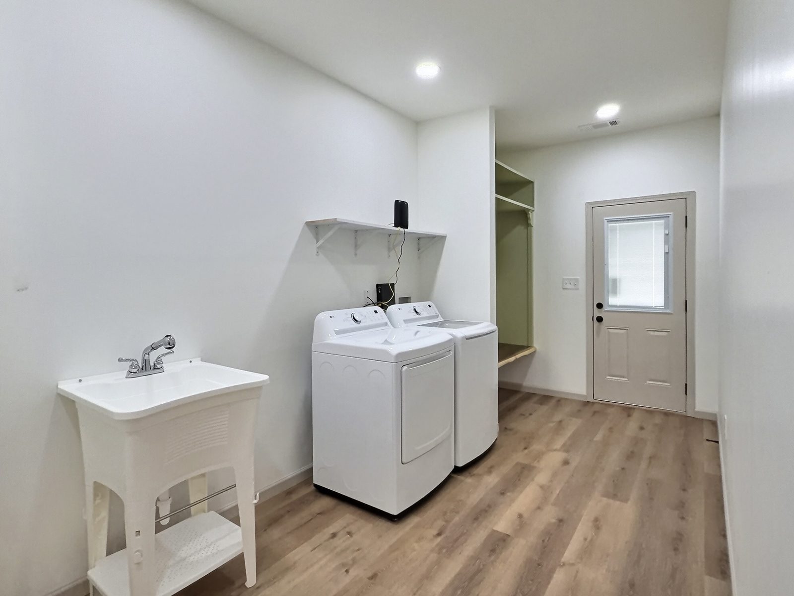 The Cedar Ranch laundry room with utility sink and exterior door