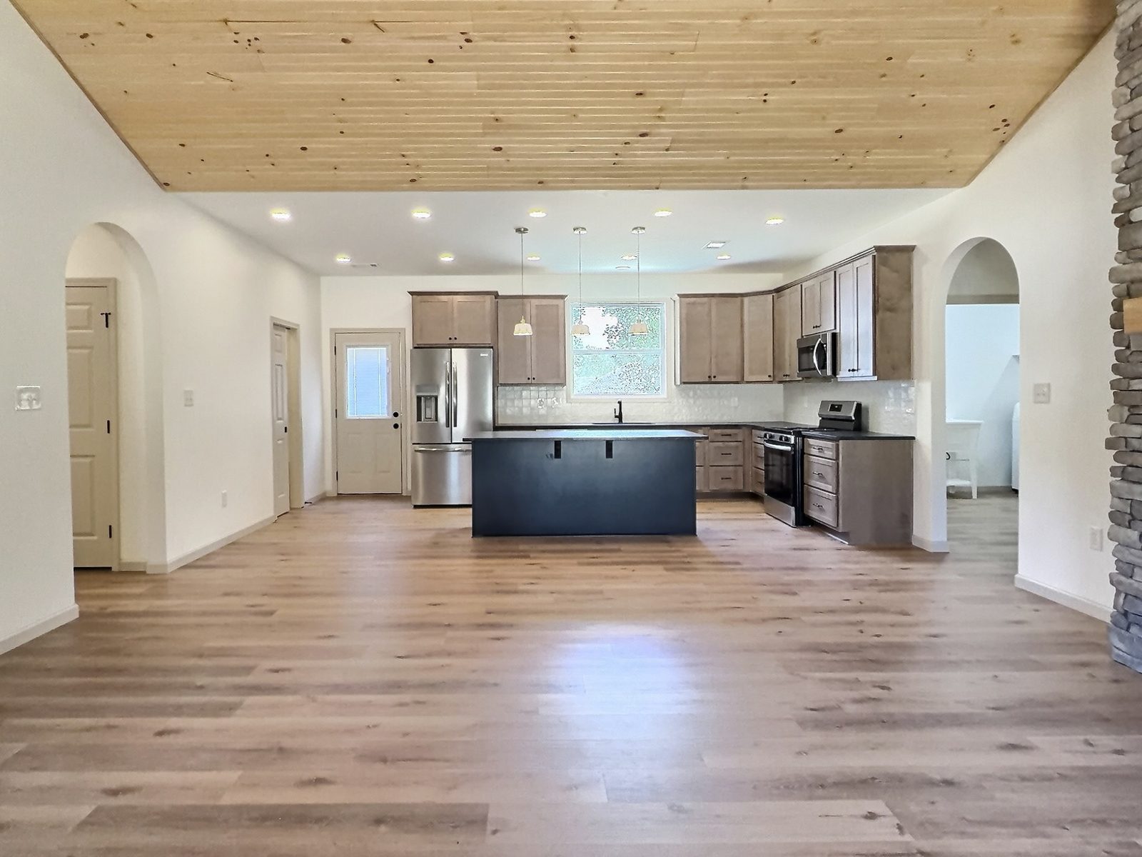 The Cedar Ranch open kitchen and living area under a wood plank ceiling