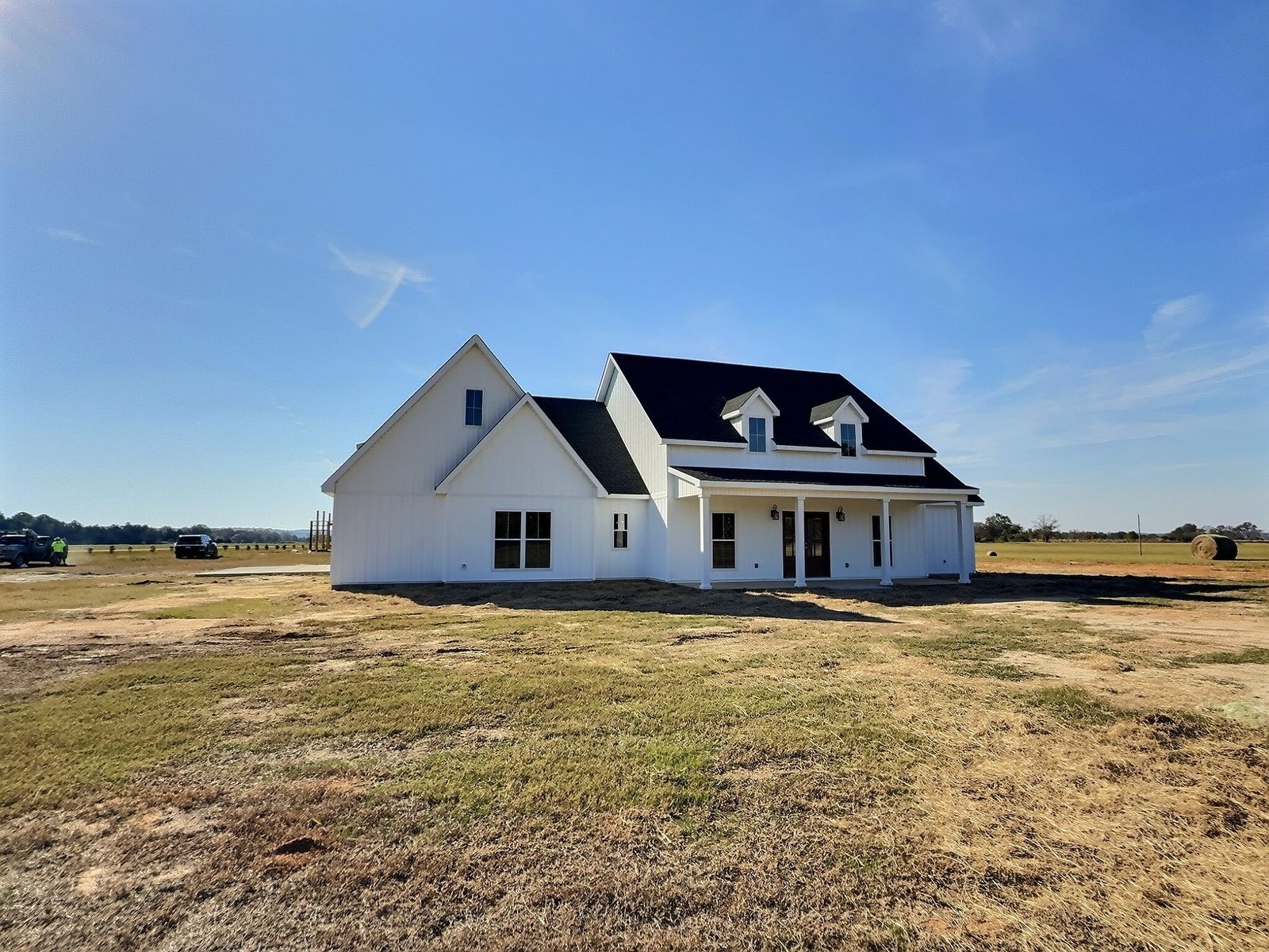 The White Farmhouse front and side exterior with dormers and covered porch