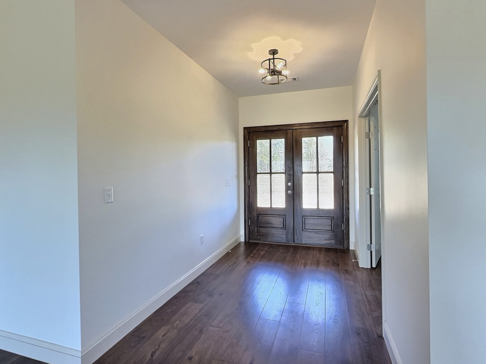 The White Farmhouse foyer with wood double doors and lantern light