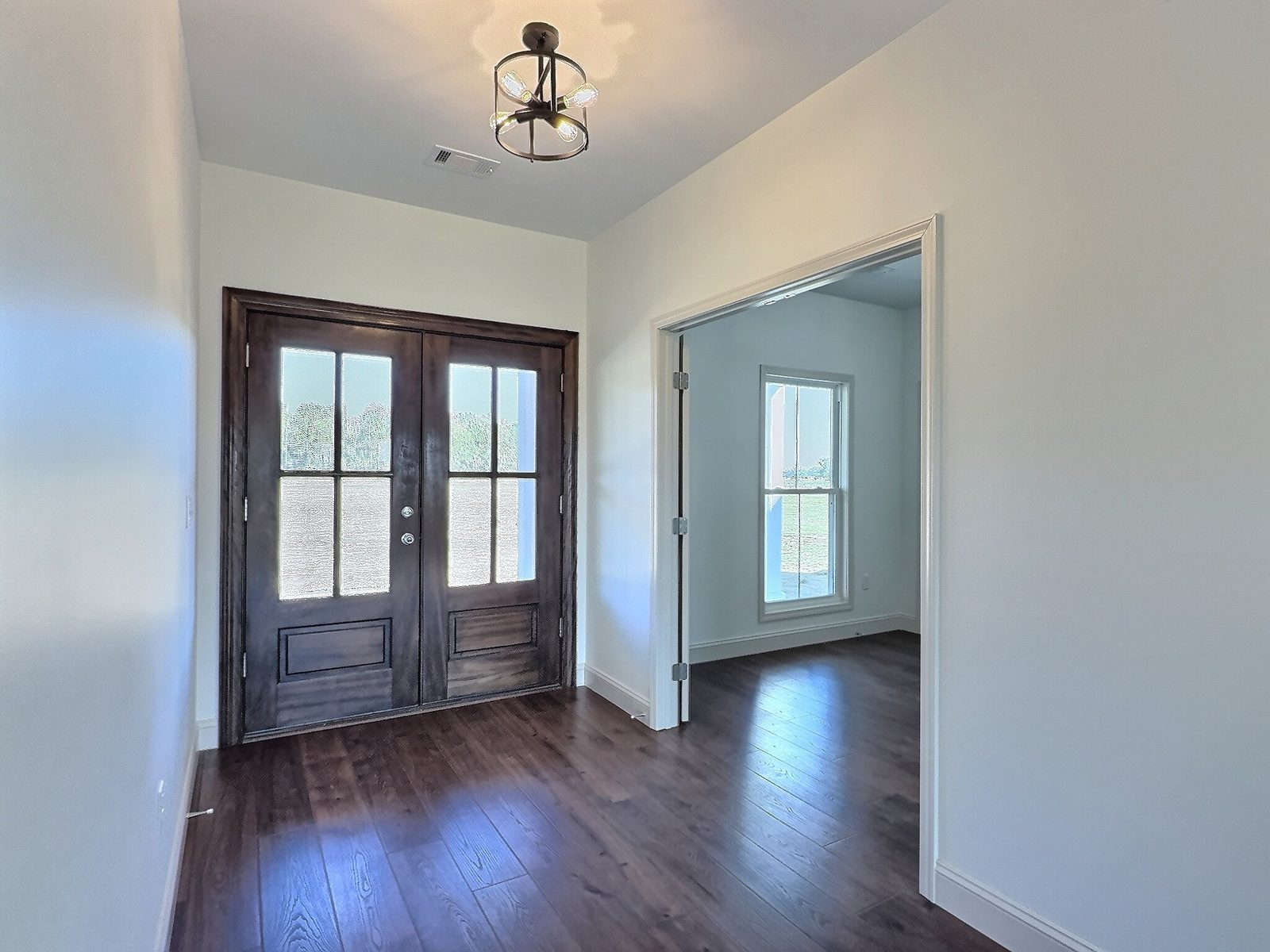 The White Farmhouse foyer with double doors and side room