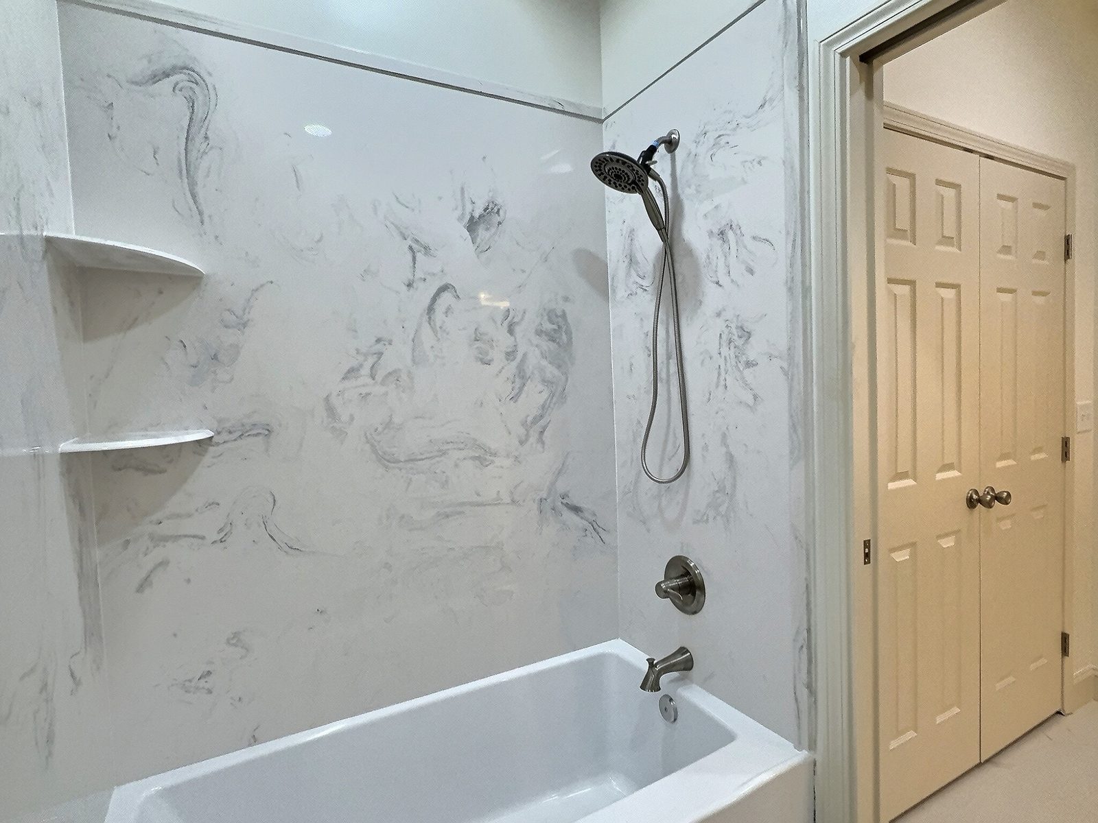 The White Farmhouse hall bath tub and shower with door