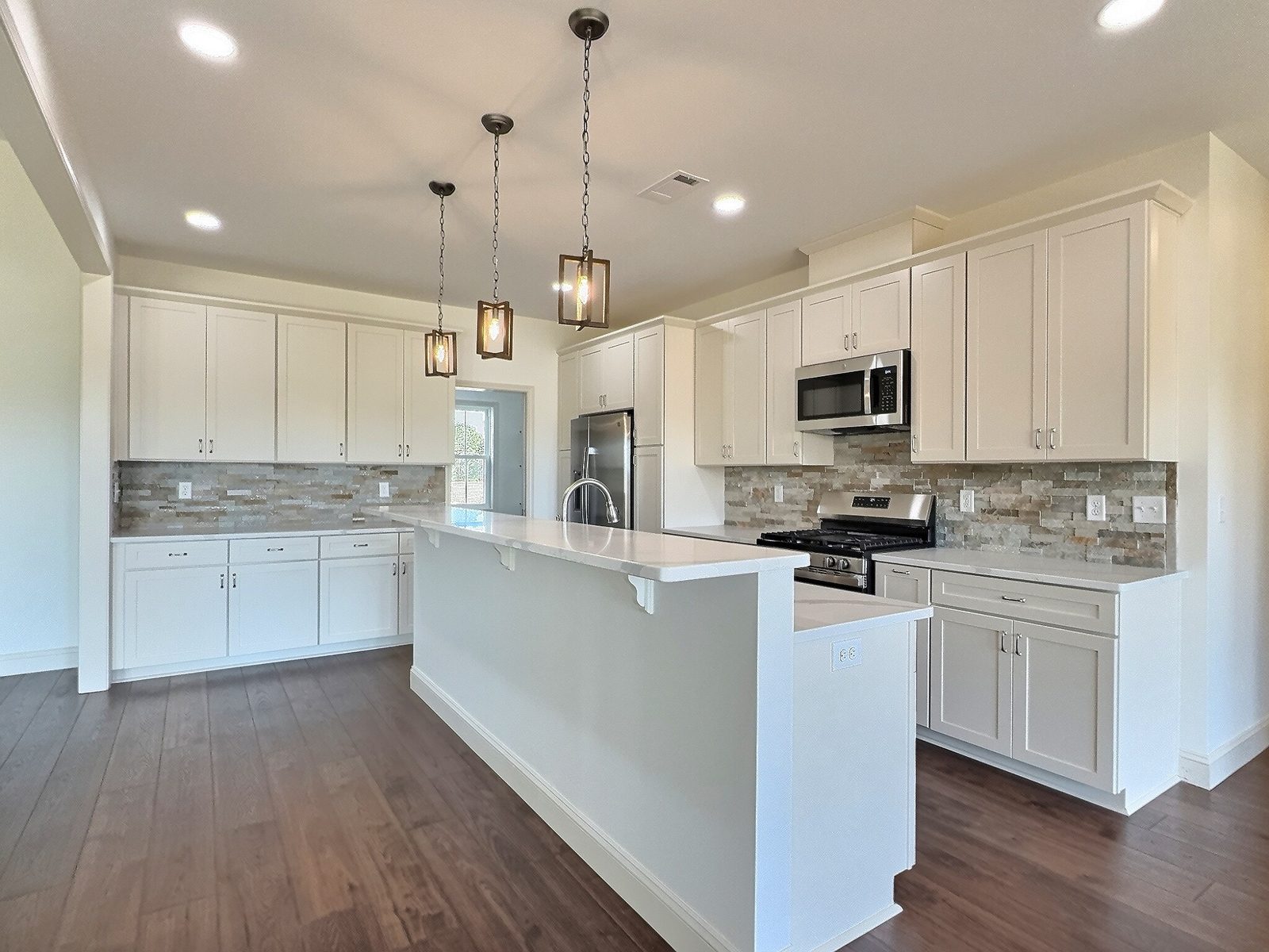 The White Farmhouse white kitchen with island and pendant lights