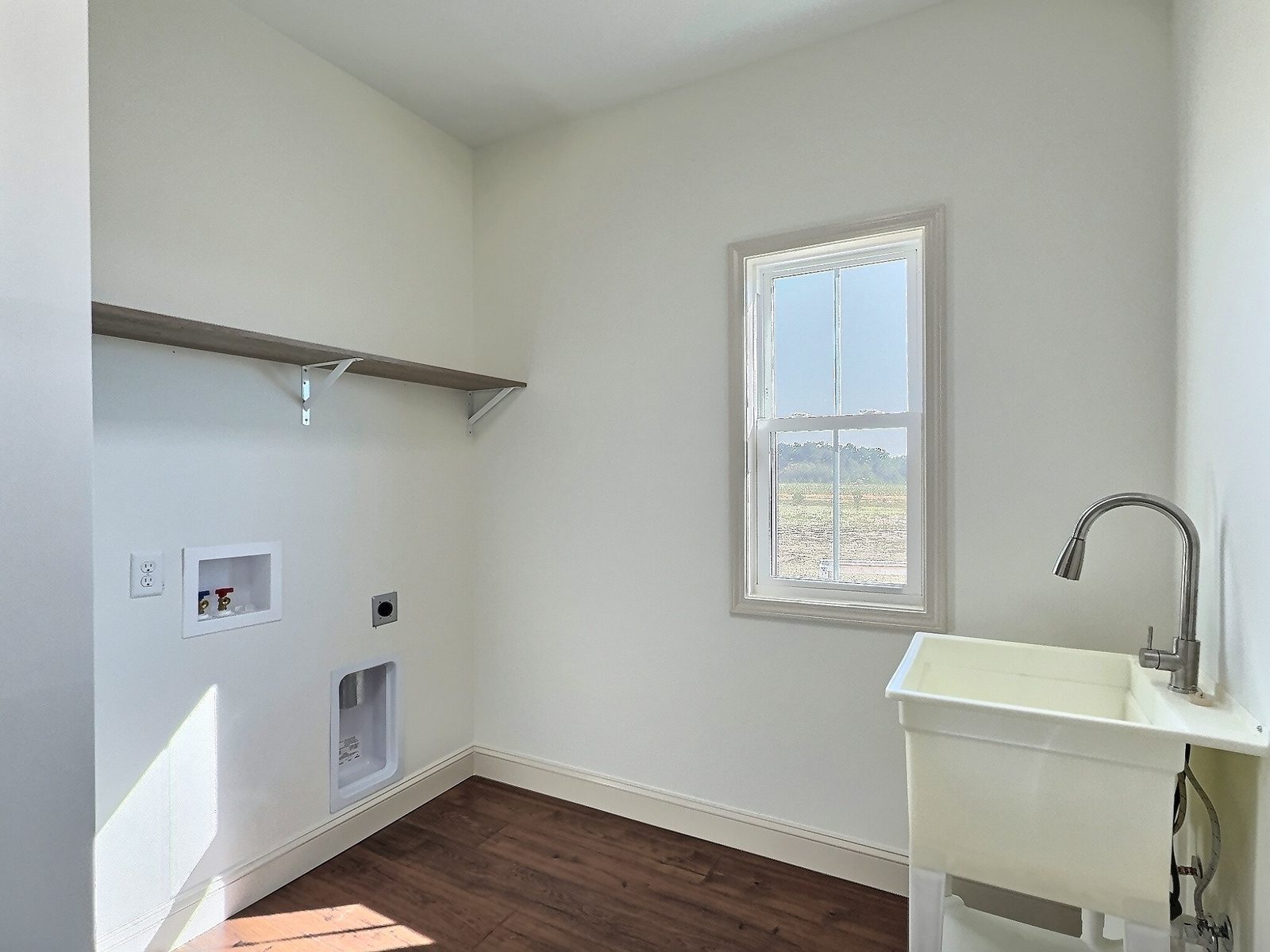 The White Farmhouse laundry room with hookups and utility sink
