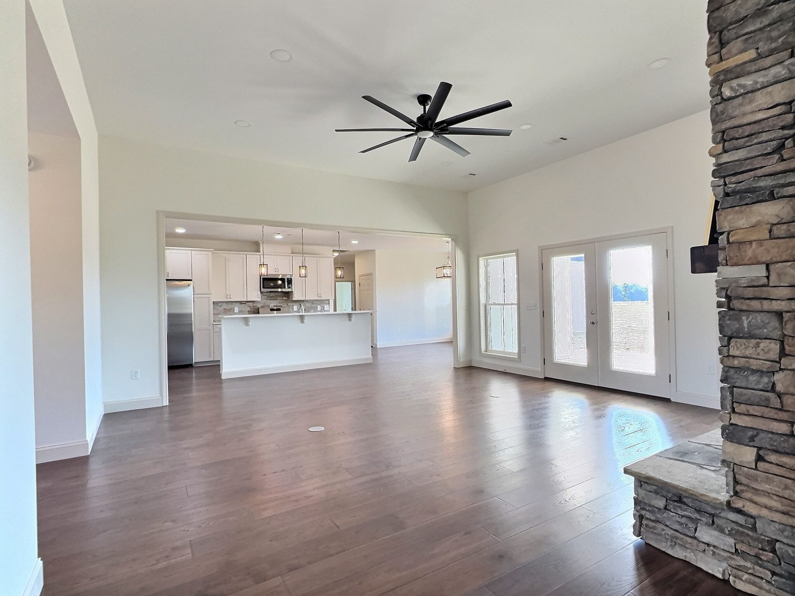The White Farmhouse living room with stone fireplace and view to the kitchen
