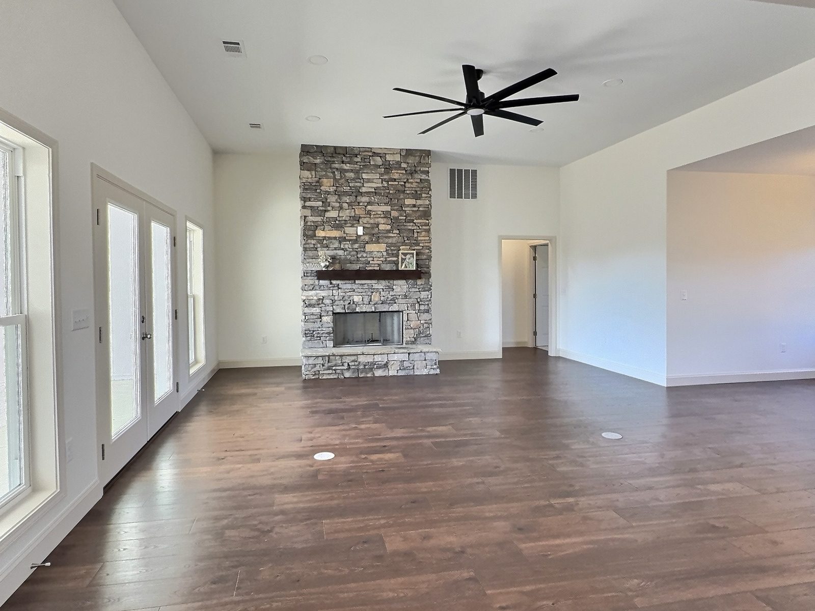 The White Farmhouse living room with stacked stone fireplace and French doors
