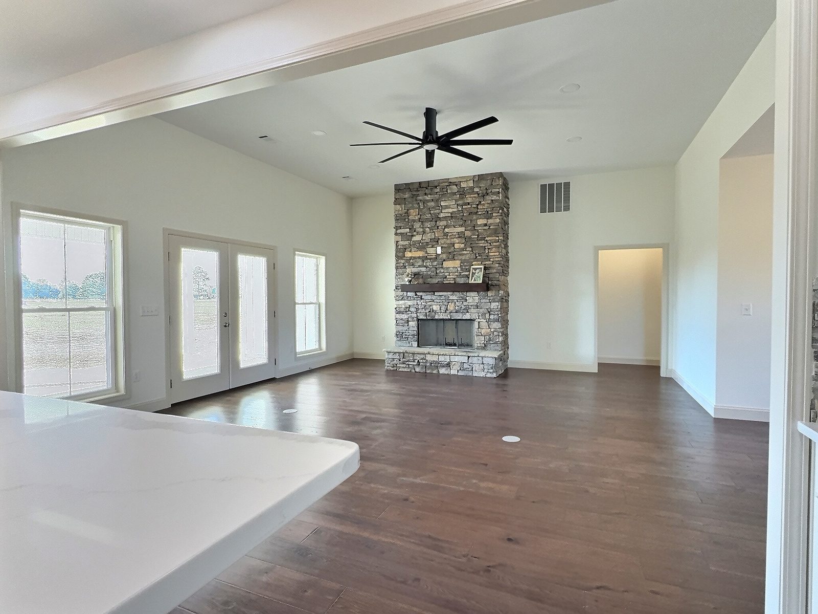 The White Farmhouse living room with stone fireplace and French doors
