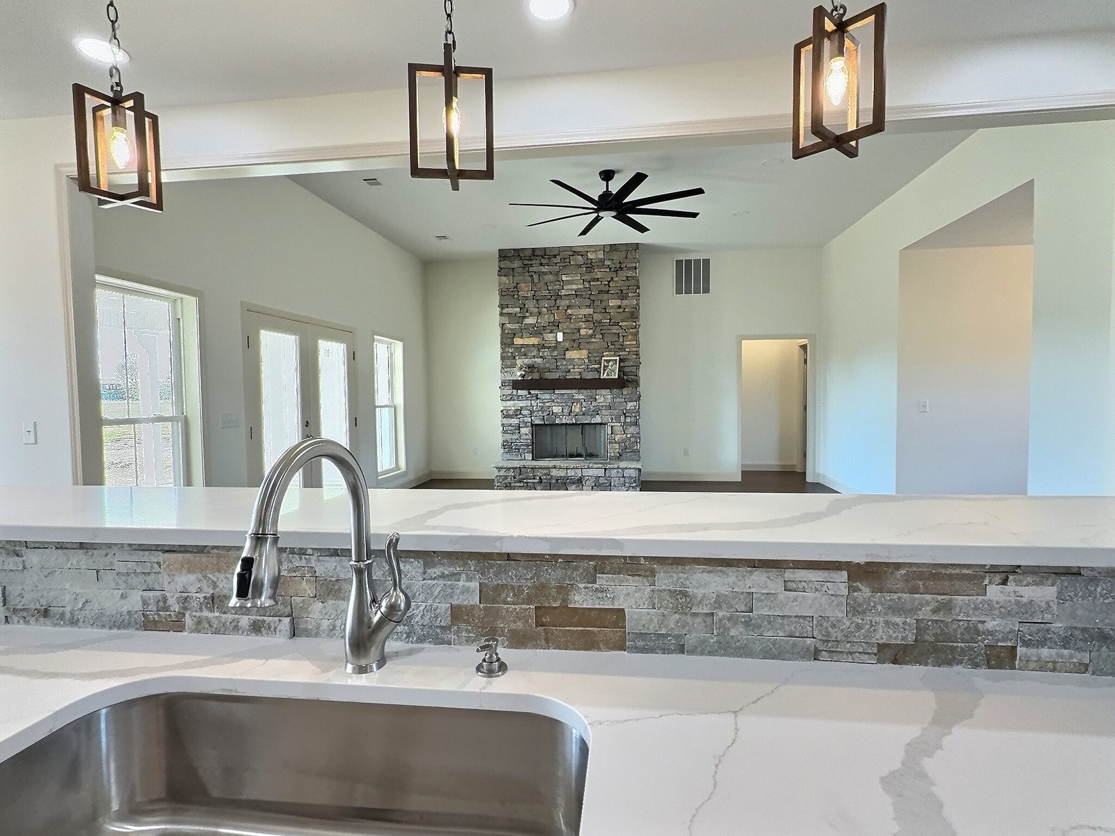 The White Farmhouse view over the kitchen sink to the living room fireplace