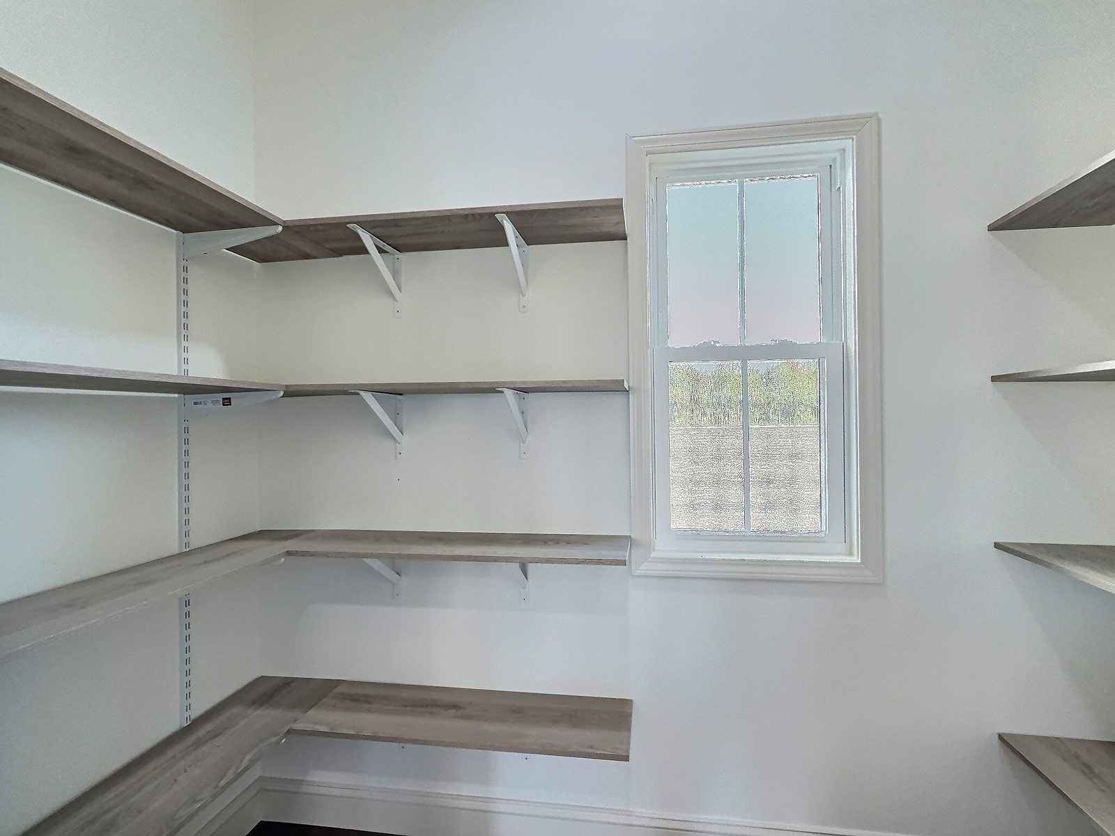 The White Farmhouse walk-in pantry with wood shelving