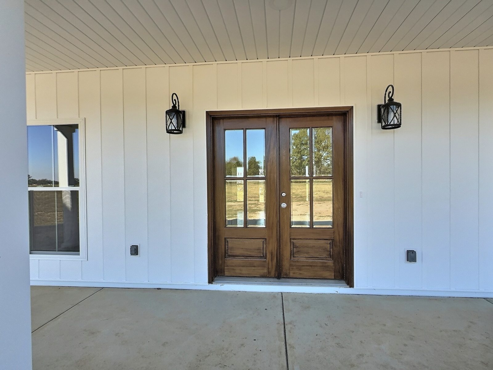 The White Farmhouse front porch with wood double doors and board-and-batten siding