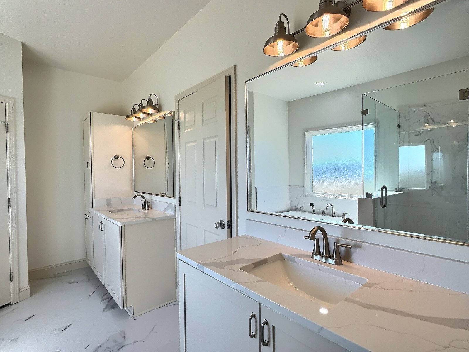 The White Farmhouse primary bath vanity with large mirror