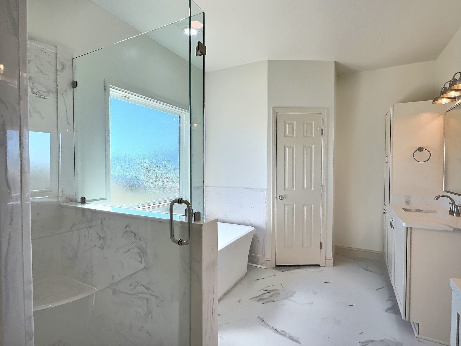 The White Farmhouse primary bath glass walk-in shower