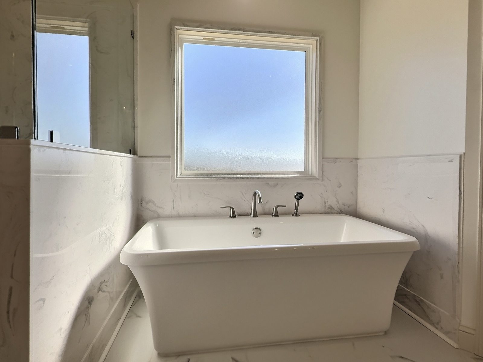 The White Farmhouse primary bath freestanding tub under the window